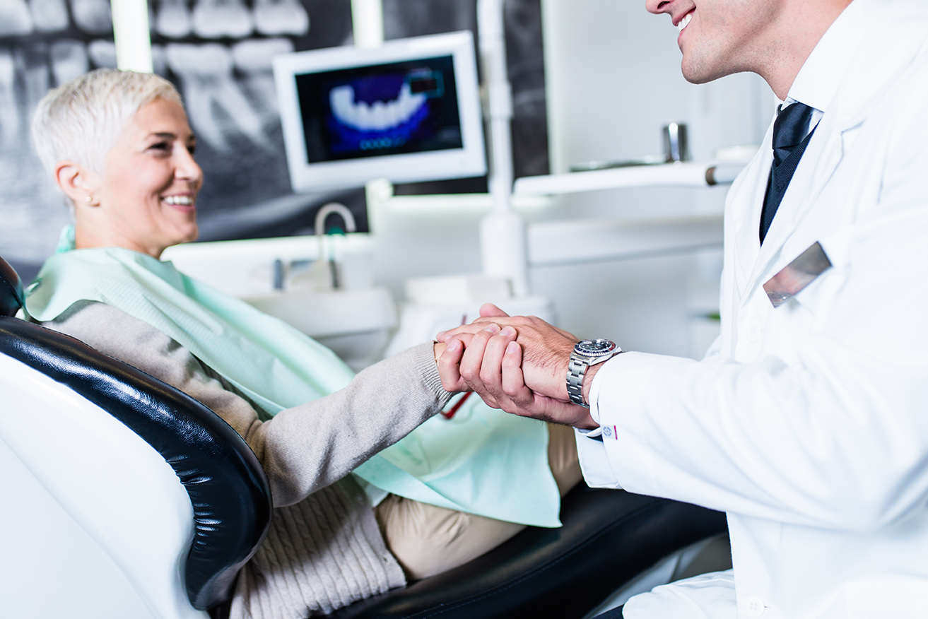 dr novak shaking dental patients hand during complete dental exam at novak dentistry at riverwalk