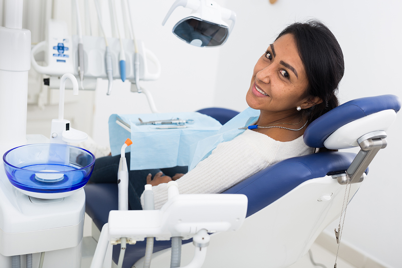 smiling dental patient sitting in dental chair at novak dentistry at riverwalk