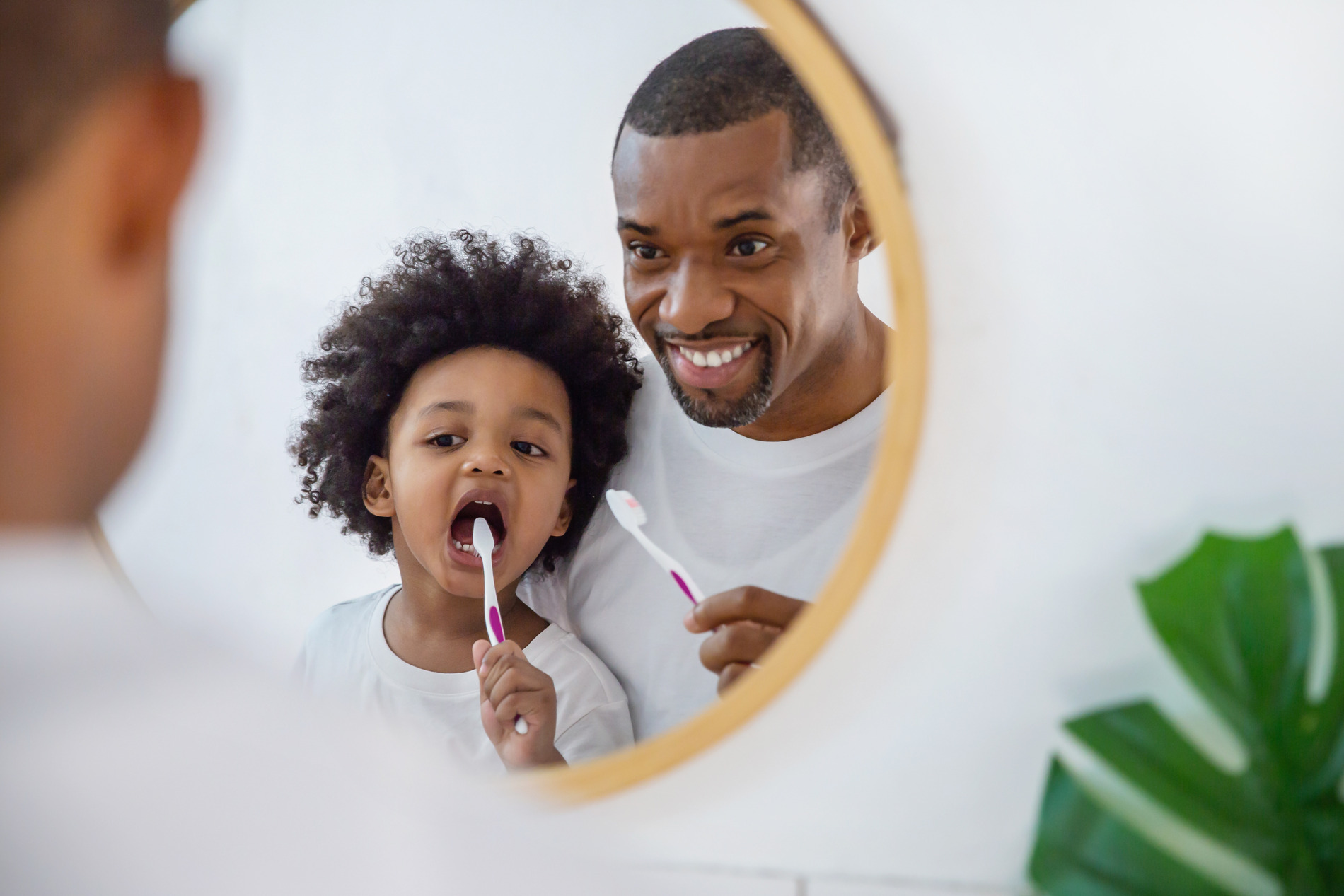 Father and son brush their teeth after family dental care in Castle Rock CO